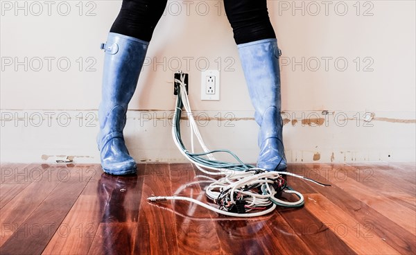 Caucasian woman wearing rain boots over electrical wiring