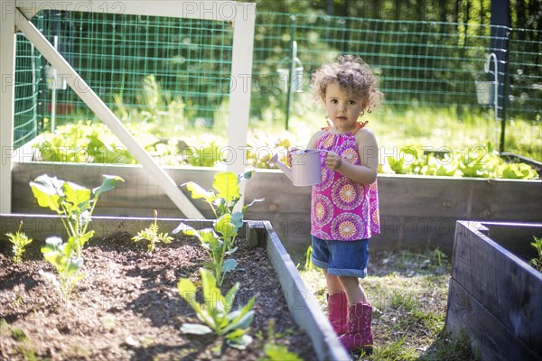 Girl watering plants in garden