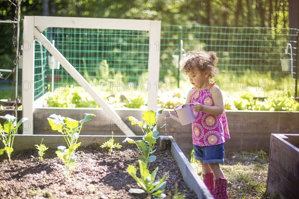 Girl watering plants in garden