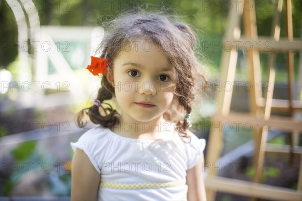 Smiling girl wearing flower in hair in garden