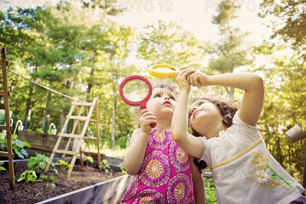 Girls examining caterpillar with magnifying glass