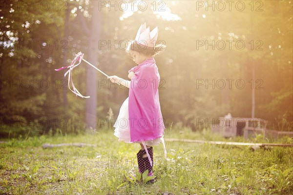 Girl playing princess in backyard