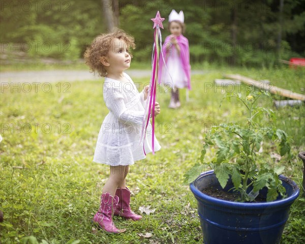 Girl playing with wand in backyard garden