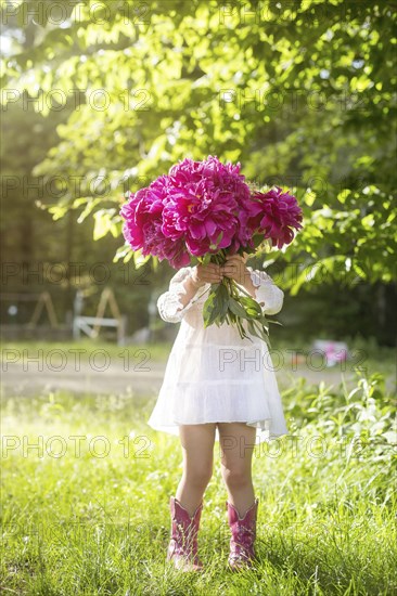 Girl holding bouquet of flowers in backyard