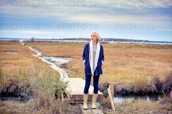 Caucasian woman standing on walkway in rural field