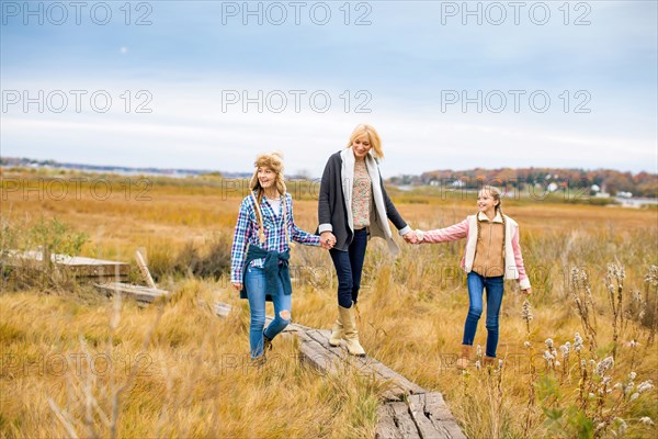 Mother and daughters walking in rural field