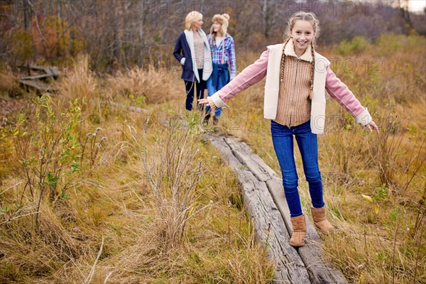 Mother and daughters walking in rural field