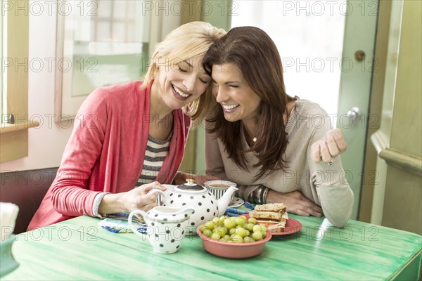 Caucasian women drinking tea laughing