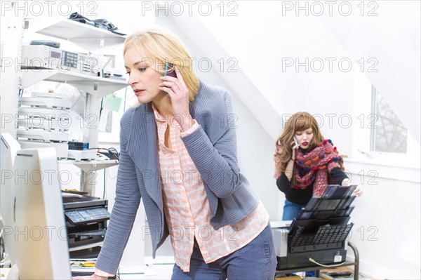 Businesswomen talking on cell phone in office