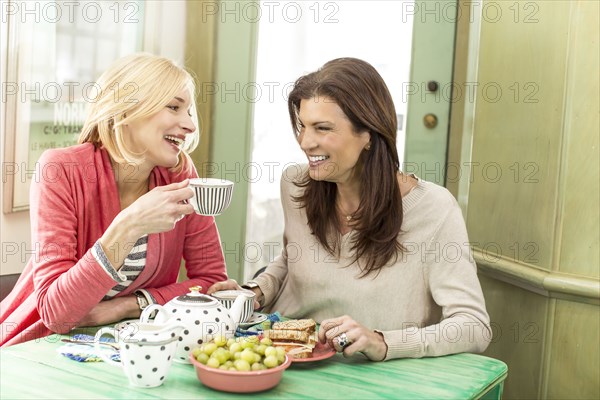 Caucasian women drinking tea and laughing
