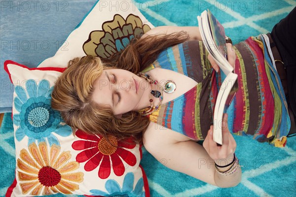 Caucasian woman reading book on floor