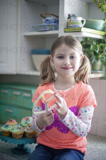 Caucasian girl licking mixing paddle in kitchen