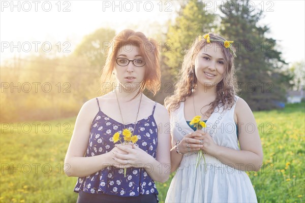 Caucasian women holding flowers in field