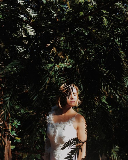 Bride wearing wedding dress under tree branches