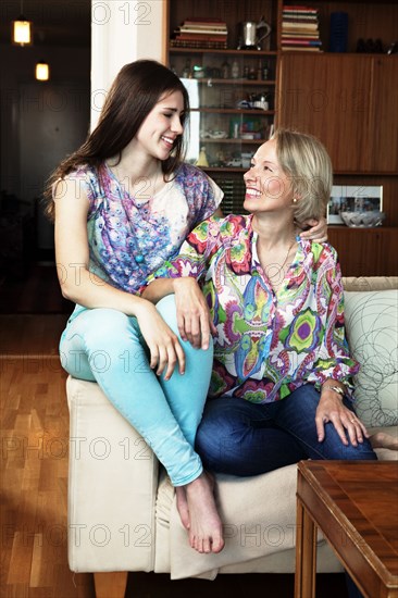 Caucasian mother and daughter sitting on sofa