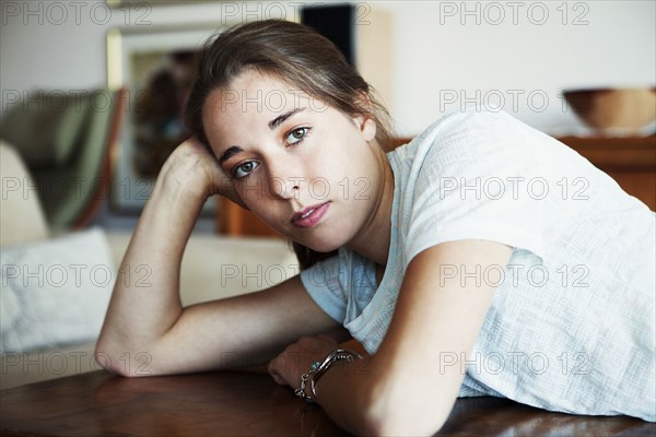 Serious woman leaning on table