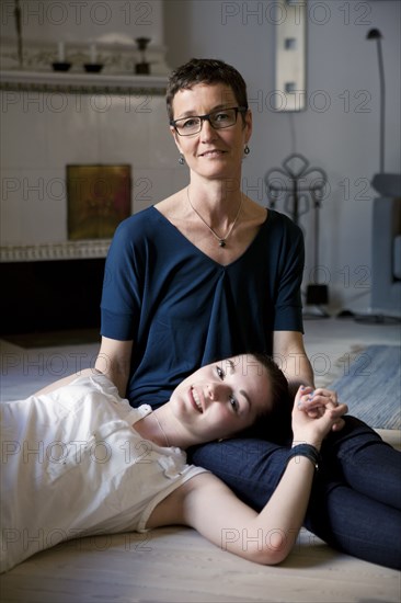 Caucasian mother and daughter hugging on floor