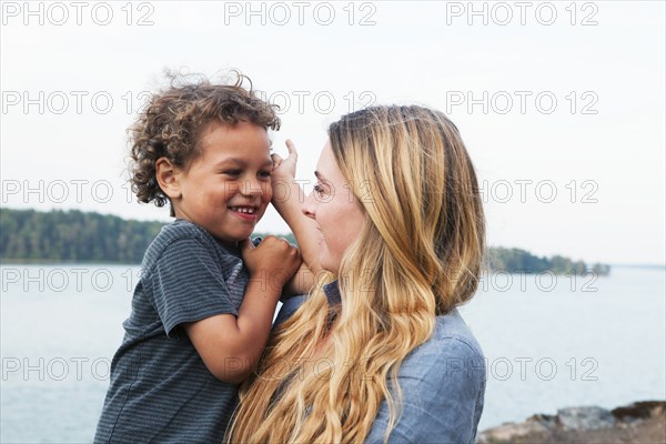 Mother holding son at rural lake