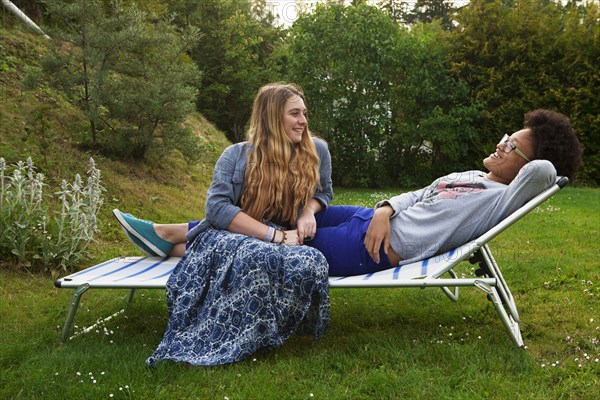 Teenage girls relaxing on lawn chair