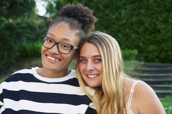 Teenage girls hugging in park