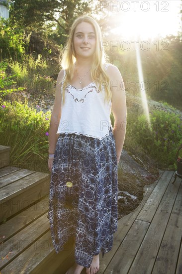 Caucasian teenage girl standing on wooden walkway