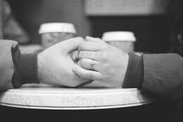 Close up of engaged couple holding hands