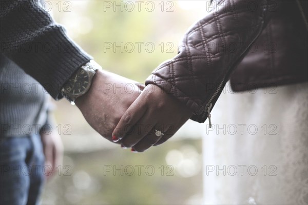 Close up of engaged couple holding hands