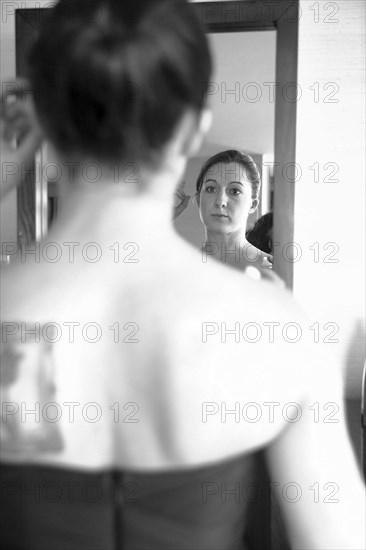 Caucasian woman admiring herself in mirror