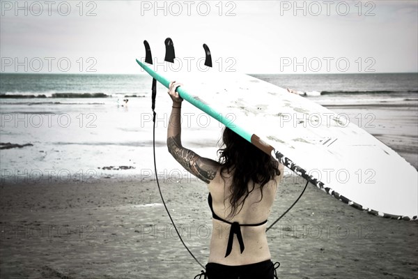 Caucasian surfer carrying surfboard on beach