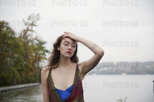 Pensive woman standing near lake