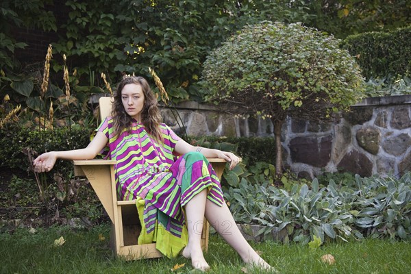 Woman sitting in lawn chair in backyard