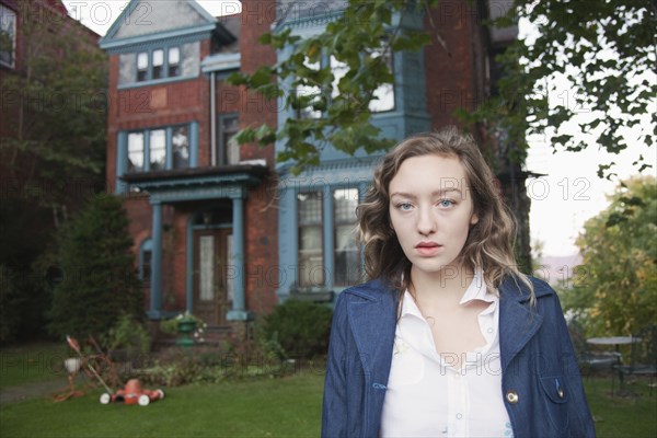 Serious woman standing in front yard