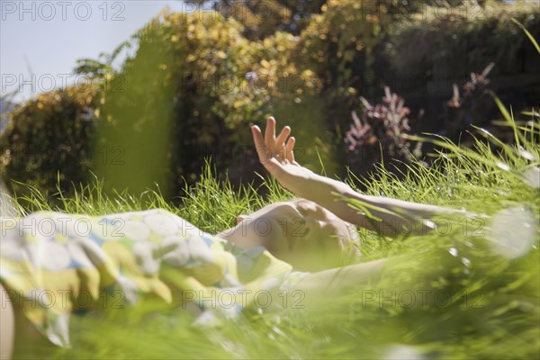 Woman laying in tall grass in park
