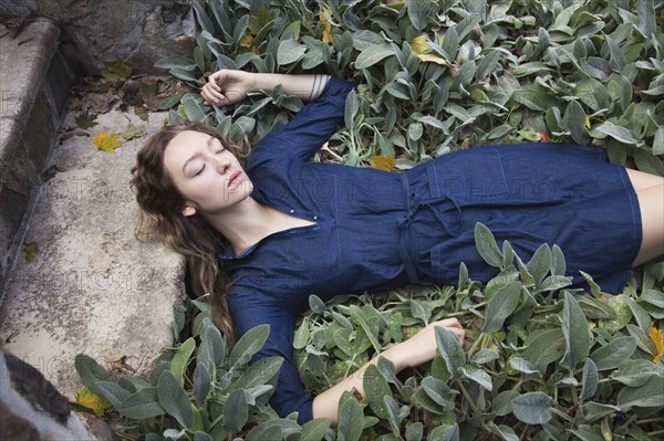 Woman sleeping in leafy garden