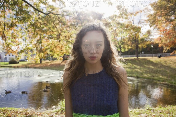 Woman standing near duck pond in park