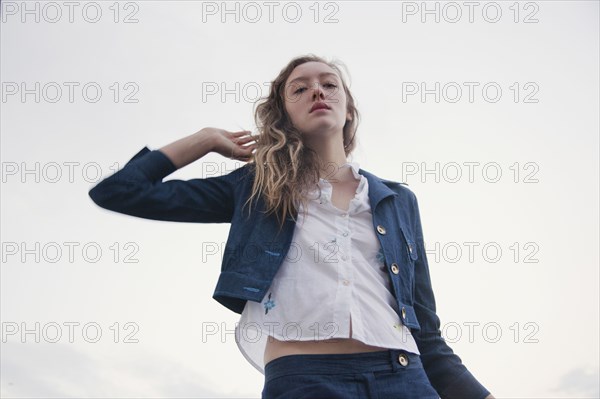 Woman wearing jacket under cloudy sky