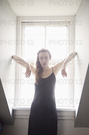 Woman standing at sunny window