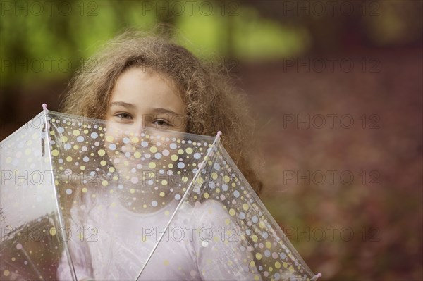 Caucasian girl playing with umbrella outdoors