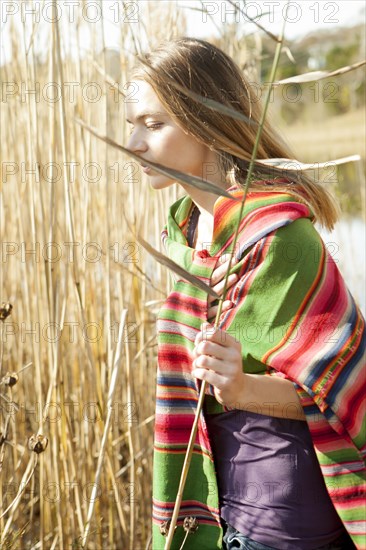 Woman standing in tall plants in marsh