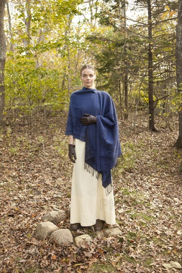 Woman wrapped in shawl in forest