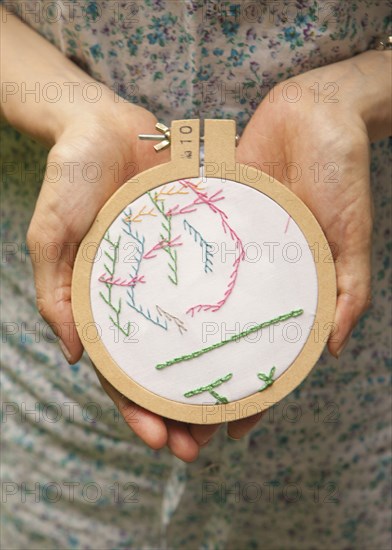 Close up of woman holding hand-stitched embroidery