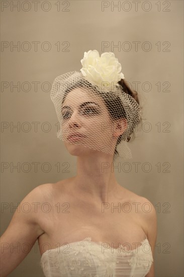 Caucasian bride wearing flower and birdcage veil