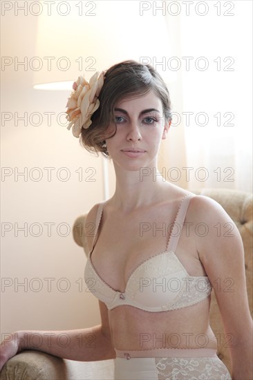 Caucasian woman in lingerie wearing flower in her hair