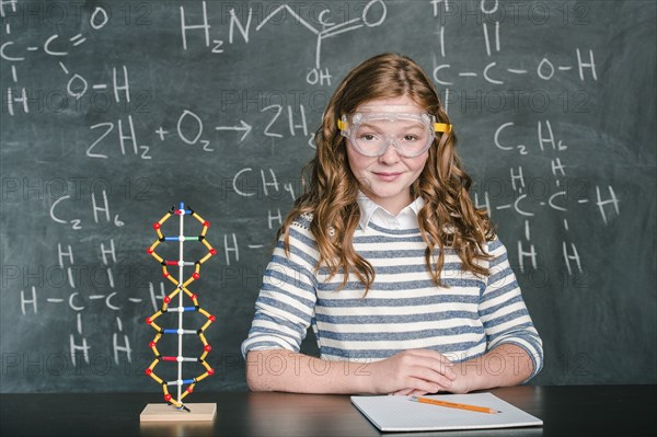 Caucasian student wearing safety goggles in science class