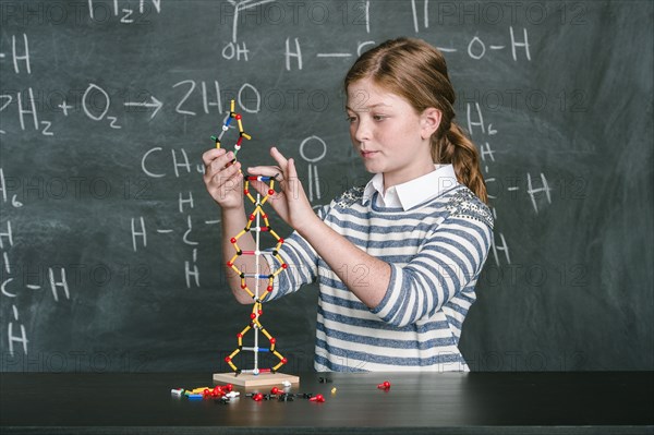 Caucasian student examining molecular model in science class