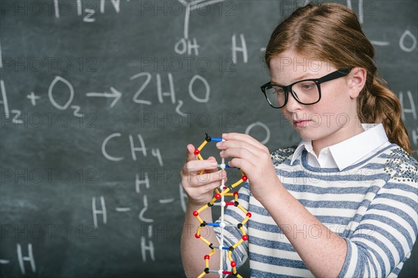 Caucasian student examining molecular model in science class