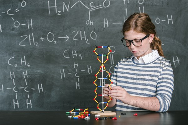 Caucasian student examining molecular model in science class