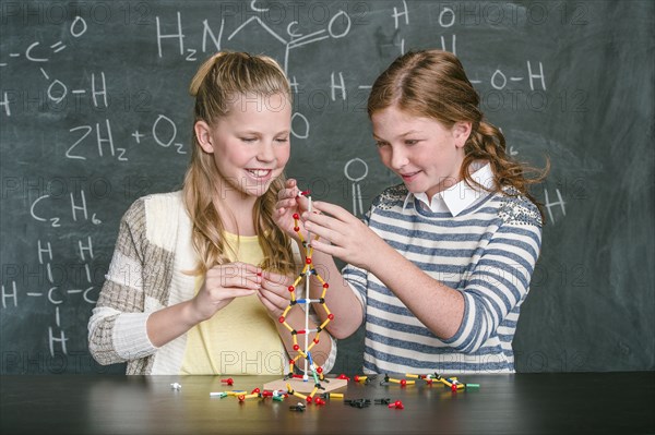 Caucasian students examining molecular model in science class