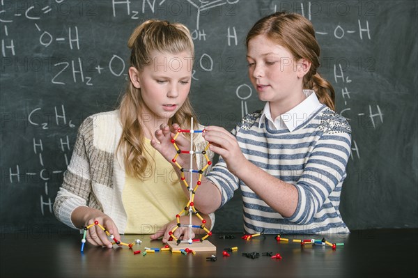 Caucasian students examining molecular model in science class