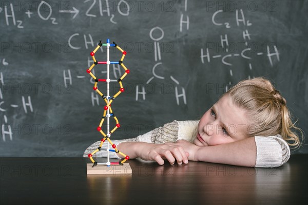 Caucasian student examining molecular model in science class